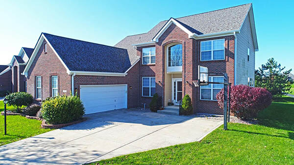 Two story brick faced home with garage in front.