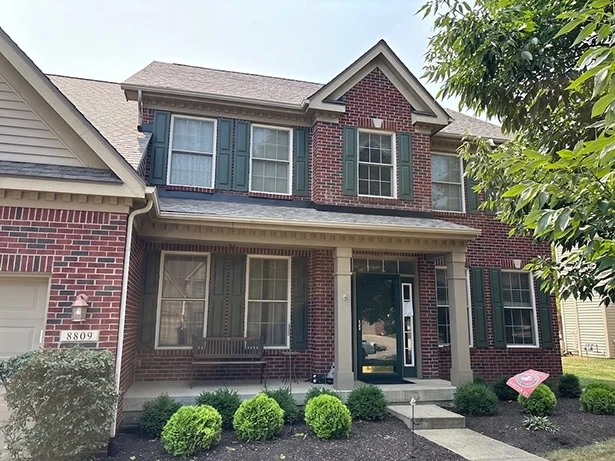 Zionsville Roof Repair by Robert Stevens Roofing on brick home Zionsville IN brick home with repaired architectural shingle roof and dark shutters – Robert Stevens Roofing