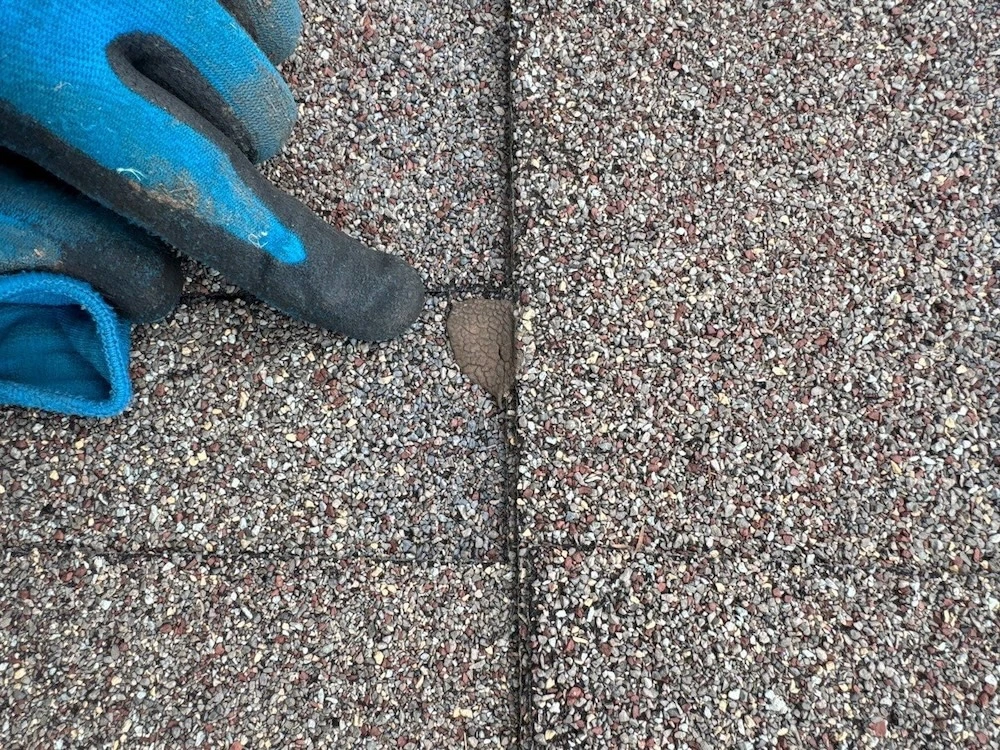 Roofing contractor inspecting asphalt shingle seams during a roof inspection in Zionsville, Indiana — Robert Stevens Roofing