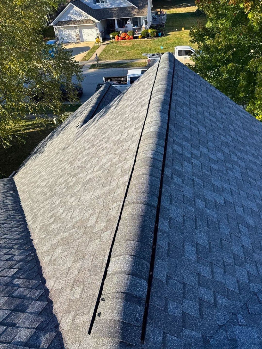 Aerial view of a residential roof ridge in Carmel, IN during an inspection by Robert Stevens Roofing